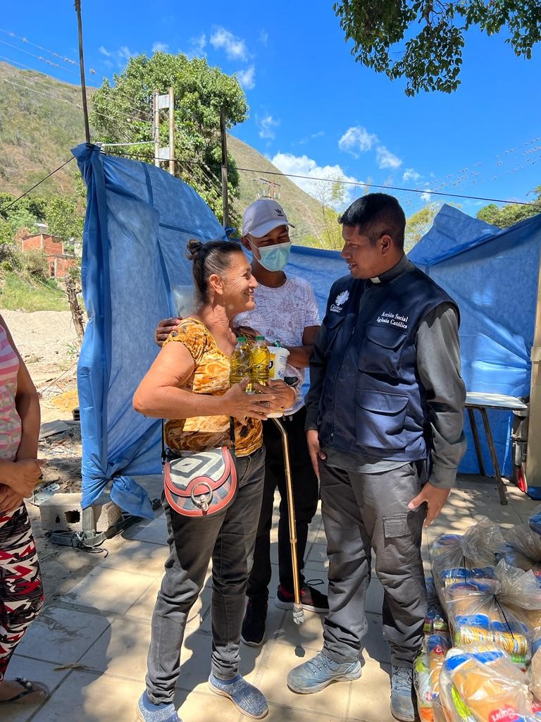 En av Caritas Venezuelas frivillige i prat med kvinne.