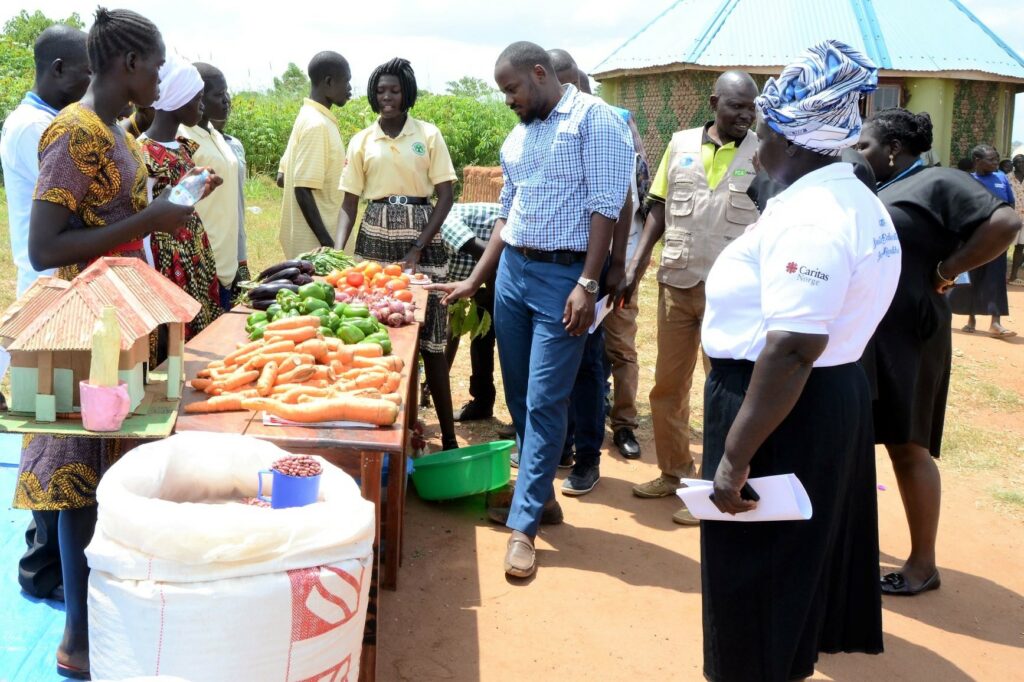 Egendyrkede grønnsaker vises frem for ledelsen i Bidibidi og Caritas Uganda i forbindelse med uteksamineringen.