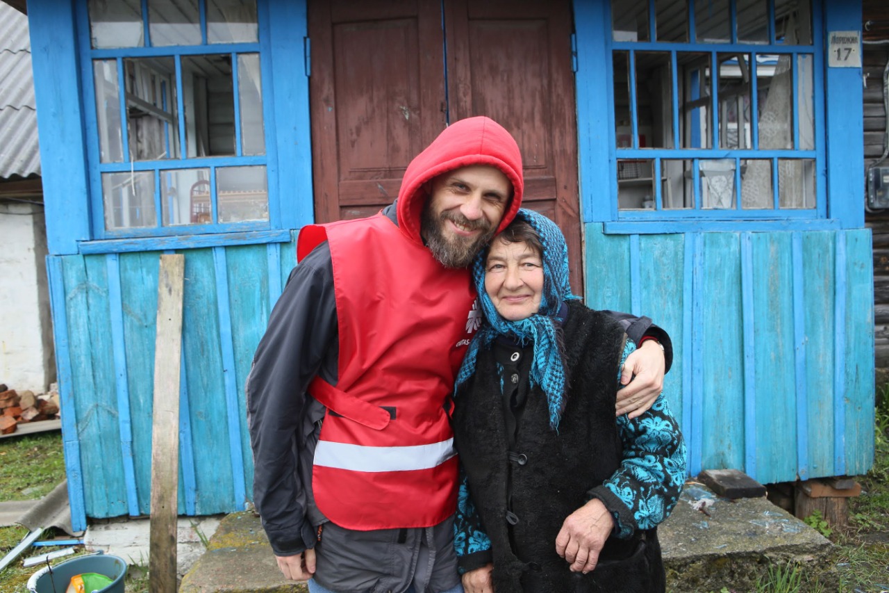 Direktør Vyacheslav Grynevych i Caritas Spes holder rundt en eldre kvinne i Øst-Ukraina.