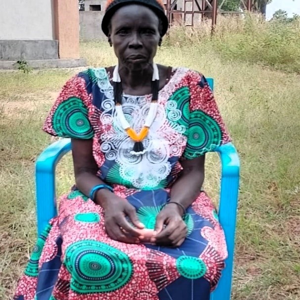 En kvinne fra Sør-Sudan i en fargerik kjole - sittende i en stol