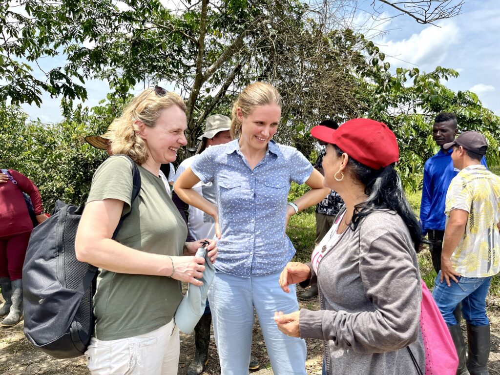 Fredrikke Storaker Kilander fra Norad og Silje Haugland, skogråd ved ambassaden i Bogota, i prat med en kvinnelig deltaker i skogbevaringsprosjektet.